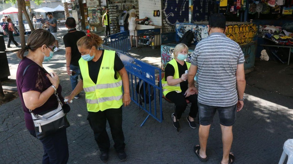 Temperature check at the entrance to The Carmel Market (the Shuk Hacarmel) (Photo: Motti Kimchi ) מדידת חום בכניסה לשוק הכרמל