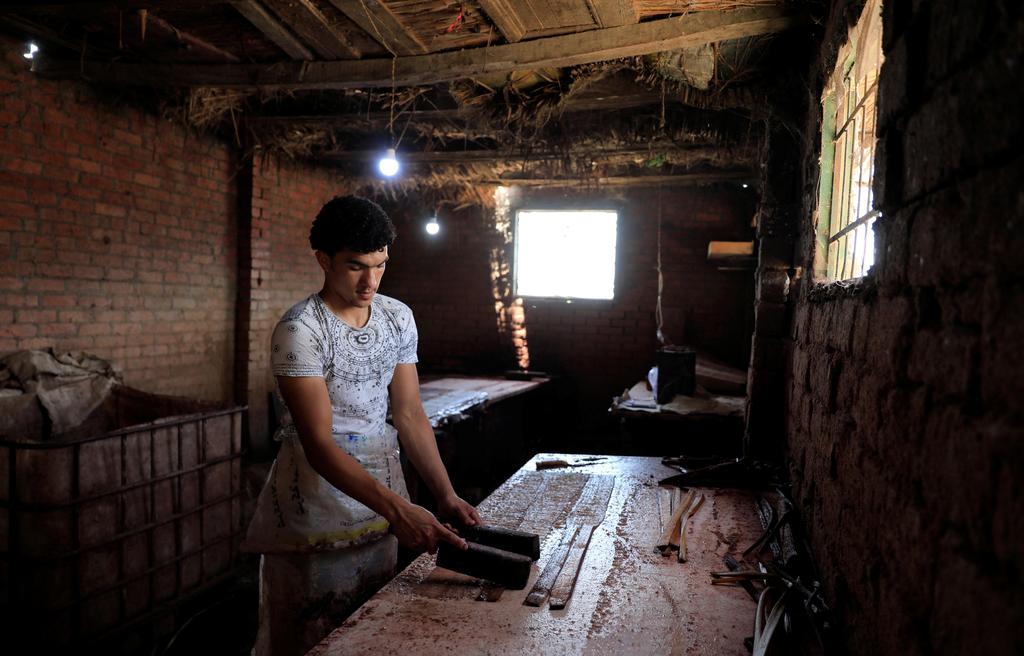 Mohamed Abdul Rahman, 18, son of a papyrus farmlands and workshops owner compresses sliced papyrus plant at a workshop in Al-Qaramous village (Photo: Reuters) Mohamed Abdul Rahman, 18, son of a papyrus farmlands and workshops owner compresses sliced papyrus plant at a workshop in al-Qaramous village