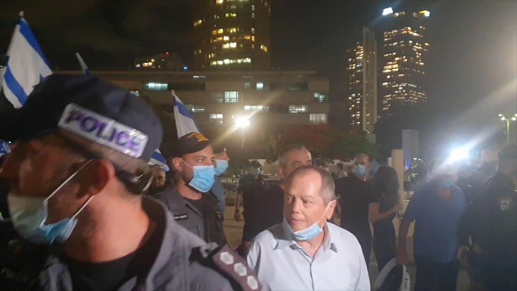 Amnon Abramovich is escorted from a right-wing protest in Tel Aviv (Photo: Courtesy) אמנון אברמוביץ'