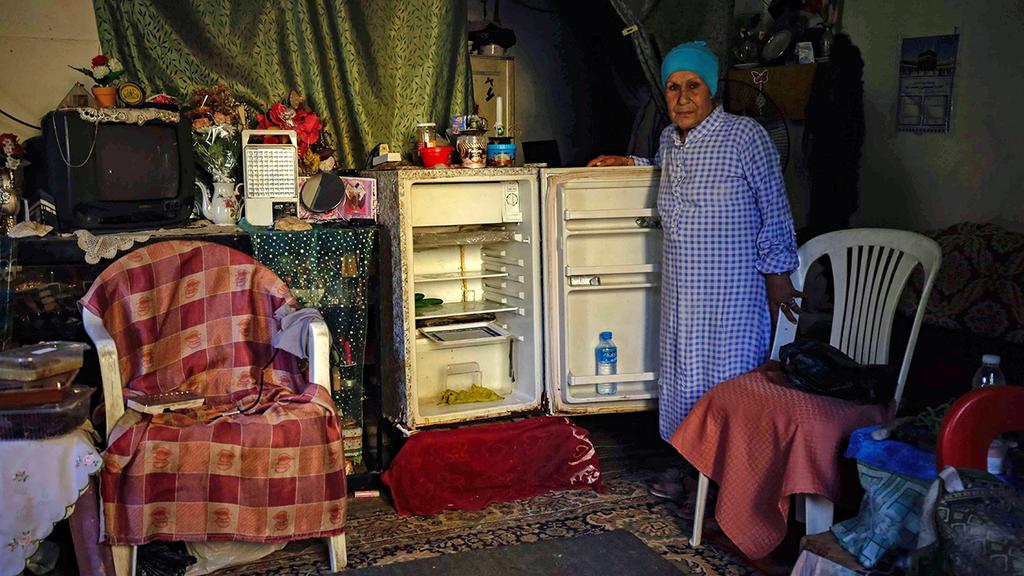 עם המקרר הריק בטריפולי. "הייתי מוכרת" (צילום: AFP) לבנון לבנונים מצטלמים ליד מקרר ריק שלהם משבר כלכלי