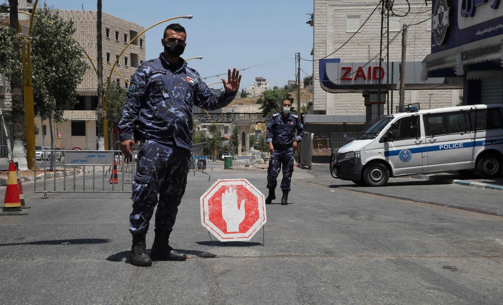 A member of the Palestinian security forces controls the cars entering the West Bank town of Hebron 