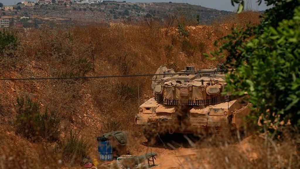 An Israeli tank remains out of site near the border with Lebanon 