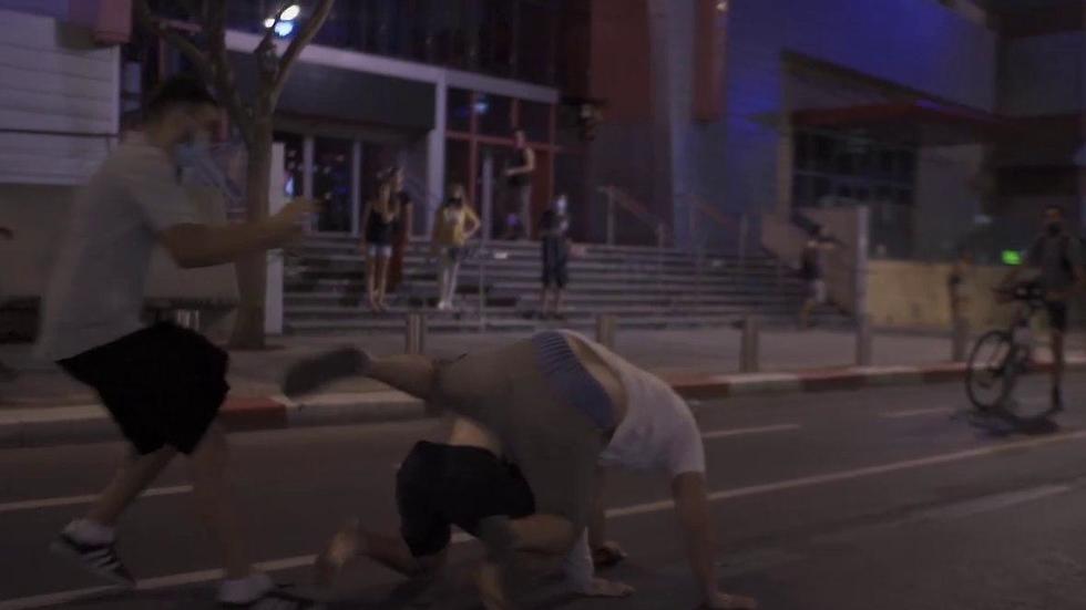 התוקפים מפילים את אחד המפגינים (צילום: אסף שפיר) מפגינים נגד נתניהו הוכו בתל אביב