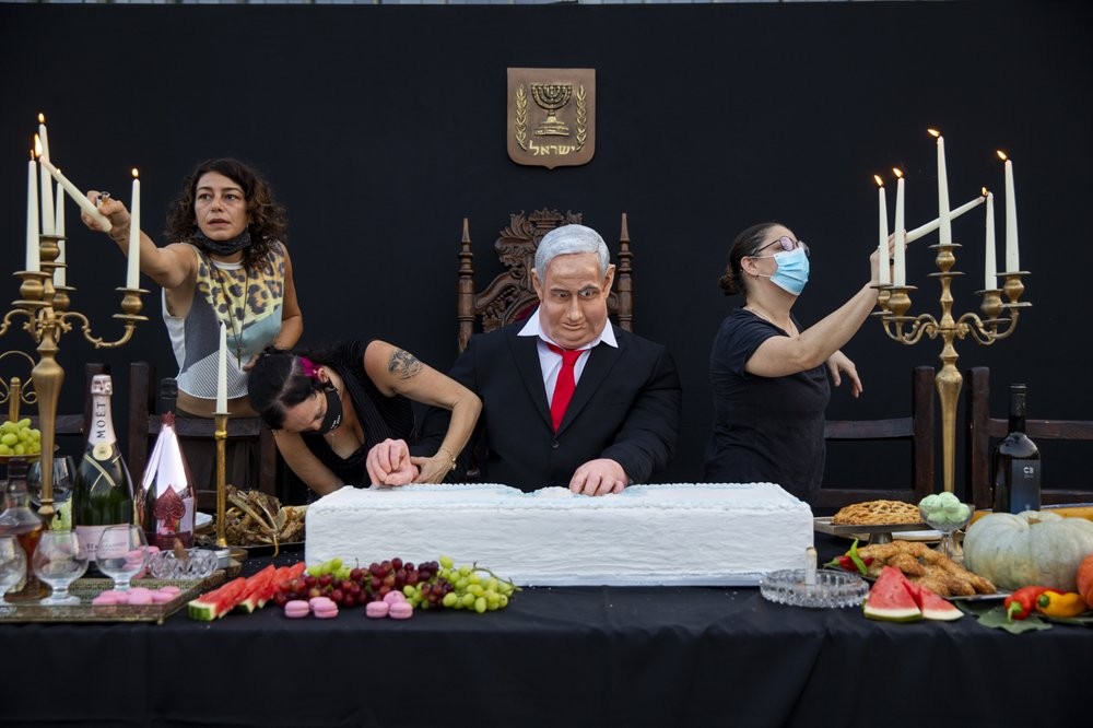 Team members of Israeli artist Itay Zalait, work on an installation depicting Prime Minister Benjamin Netanyahu at a mock "Last Supper" at Rabin square in Tel Aviv 