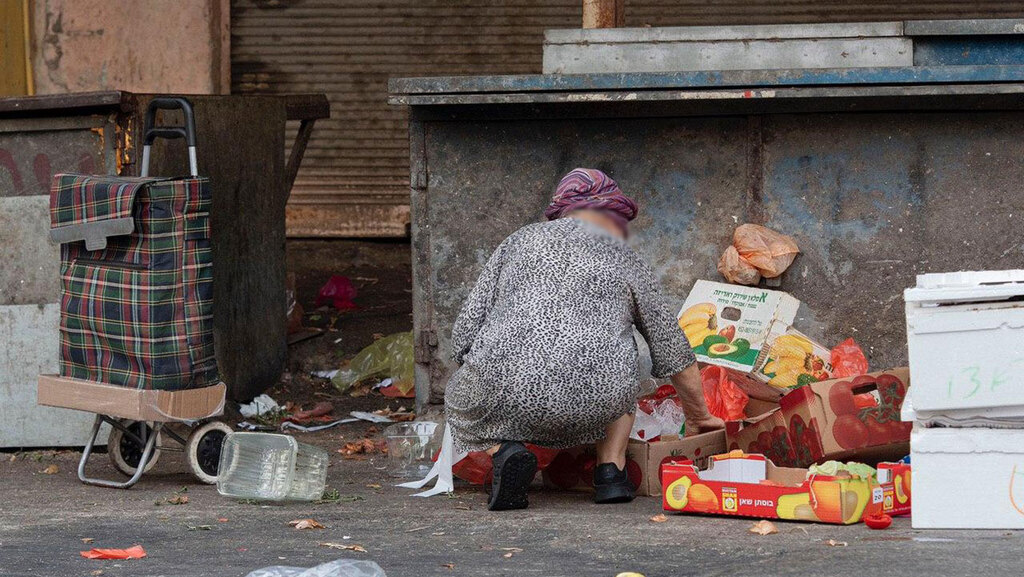 An Israeli woman scavenges for food in discarded trash during the coronavirus crisis (Photo: Nadav Abas) אנשים מחפשים אוכל בפחים בצל משבר הקורונה