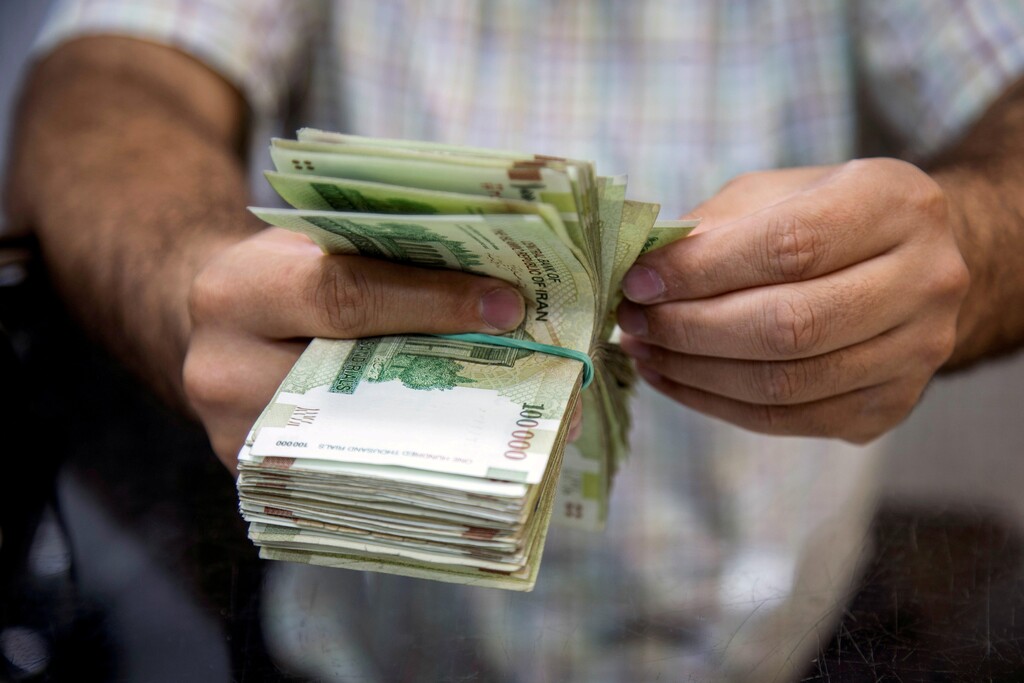 A salesman counts money in Tajrish Bazaar, Tehran 