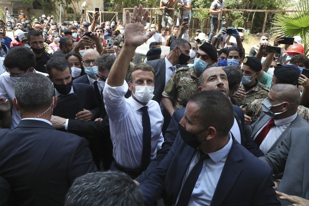 French President Emmanuel Macron, center, gestures as he visits the Gemayzeh neighborhood, which suffered extensive damage from an explosion on Tuesday that hit the seaport of Beirut, Lebanon 