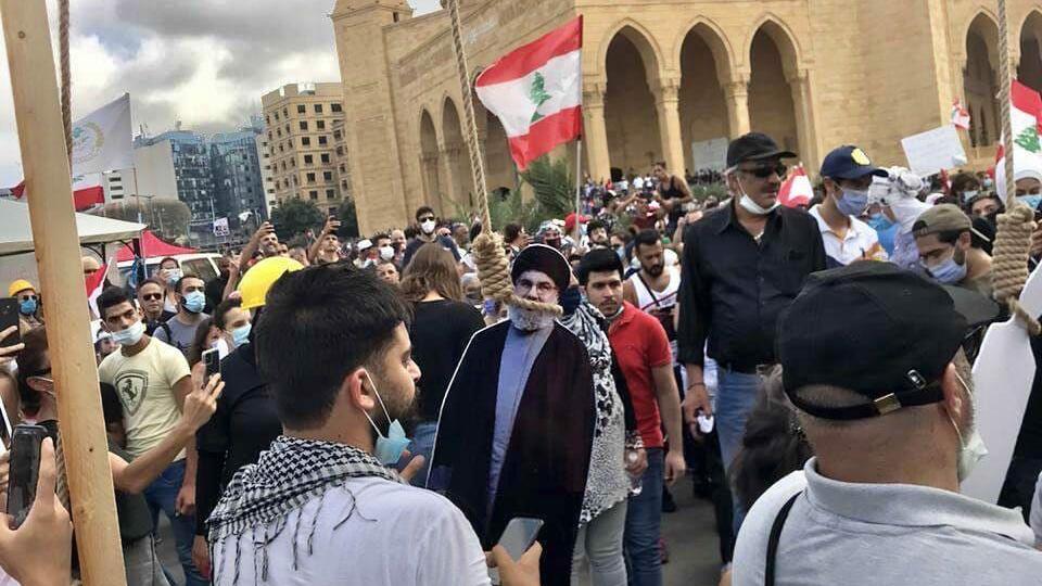 מפגינים נגד האליטה הפוליטית "תולים" את נסראללה בביירות, אחרי אסון הפיצוץ התפרעויות בביירות
