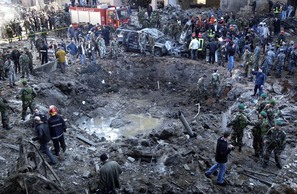 Rescue workers and soldiers stand around a massive crater after a bomb attack that tore through the motorcade of former Prime Minister Rafik Hariri (Photo: AP) Rescue workers and soldiers stand around a massive crater after a bomb attack that tore through the motorcade of former Prime Minister Rafik Hariri