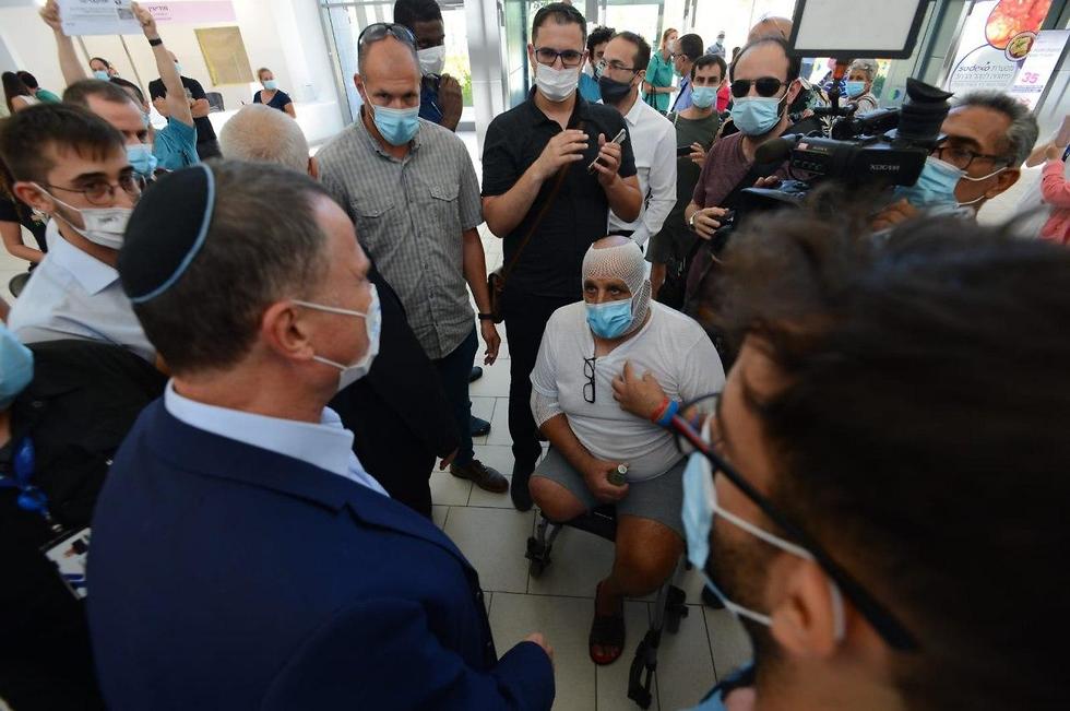 אדלשטיין עונה למוחים (צילום: אבי רוקח) מחאת מתמחים בסיור שר הבריאות אדלשטיין