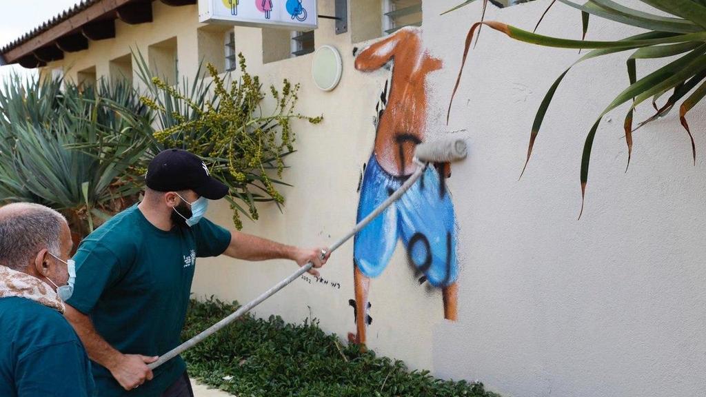 מחיקת ציור הקיר מחוף מציצים (צילום: גיא יחיאלי) מחיקת ציור קיר מחוף מציצים