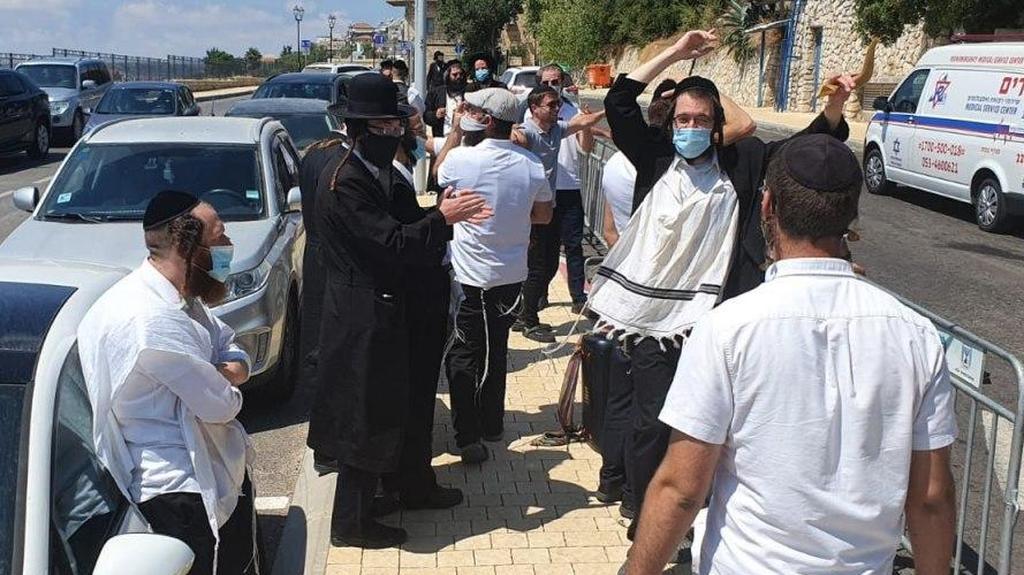 החסידים מחוץ למלון (צילום: אומן סטטוס) חסידים מפגינים מול מלון רות שבו שוהה בנימין נתניהו