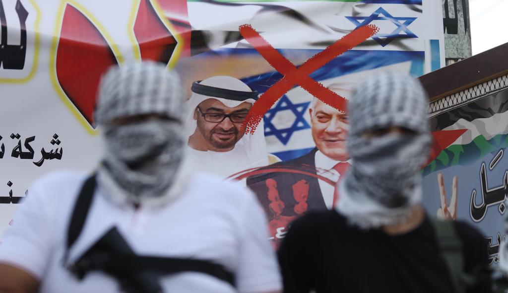 Palestinian Fatah members hold their guns during a protest against the peace agreement to establish diplomatic ties between Israel and the United Arab Emirates