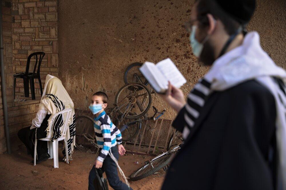 Ultra-Orthodox Jews pray outside their Bnei Brak home (Photo: AP) ultra-Orthodox Jews pray a morning prayer next to their house as synagogues limited to twenty people following the government's measures to help stop the spread of the coronavirus in Bnei Brak, Israel