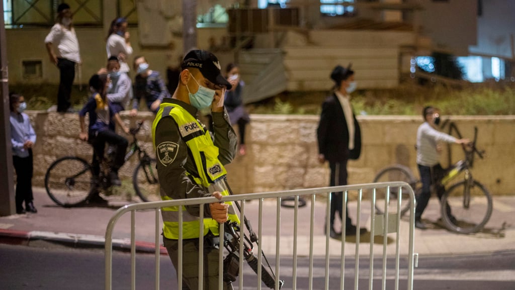 נערכים לסגר הכללי בבית שמש (צילום: AP) שוטר מג"ב מציב מחסום בשכונה בבית שמש סגר לילי קורונה