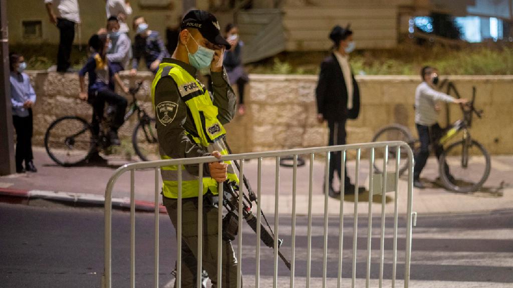 סגר לילי בבית שמש (צילום: AP) שוטר מג"ב מציב מחסום בשכונה בבית שמש סגר לילי קורונה