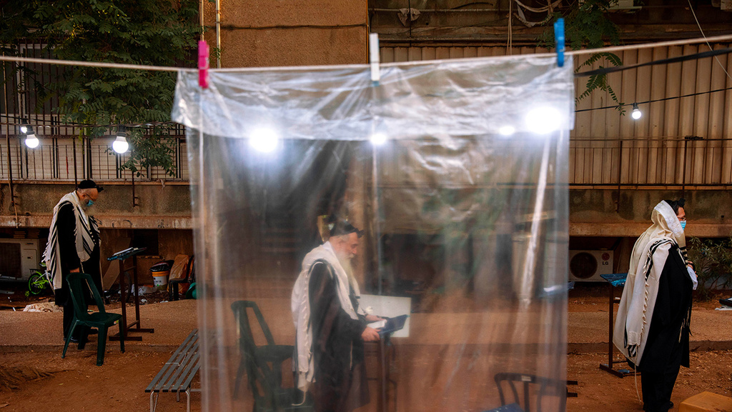 Religious Jews observing social distancing as they pray outdoors in Bnei Brak (Photo: AP) מתפללים בבני ברק