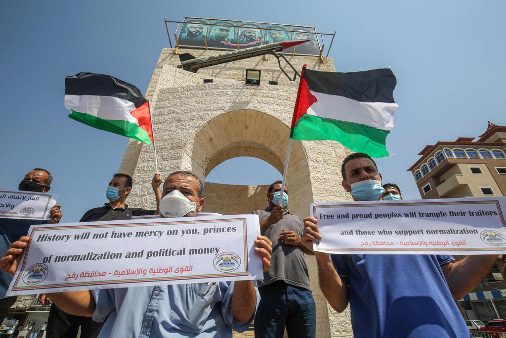 Palestinians carry placards during a protest in Rafah in the southern Gaza Strip, on September 12, 2020, to condemn the normalisation of ties between Israeli and Bahrain