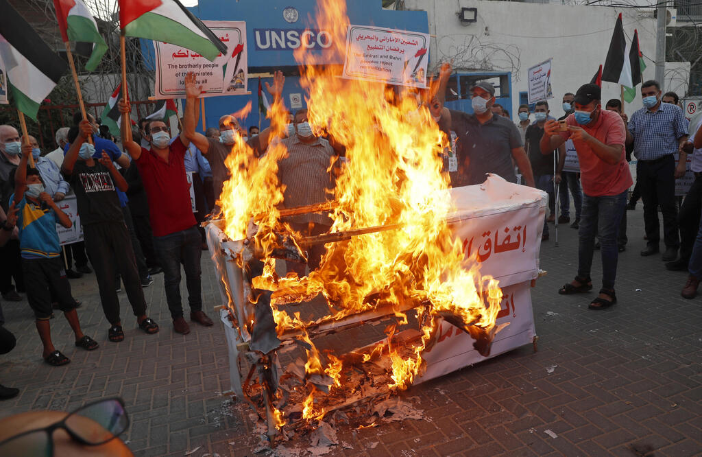 Palestinians burn mock coffins representing the United Arab Emirates and Bahraini normalization agreements with Israel