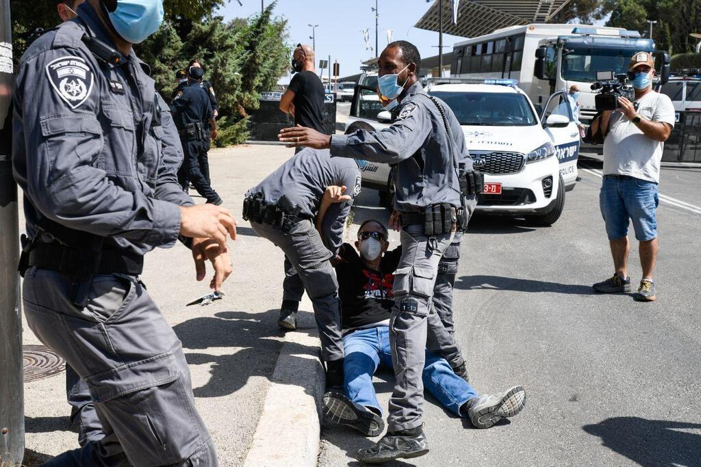 שוטרים עוצרים מפגין בירושלים (צילום: שלו שלום) הפגנת הדגלים השחורים נגד חוק הגבלת ההפגנות