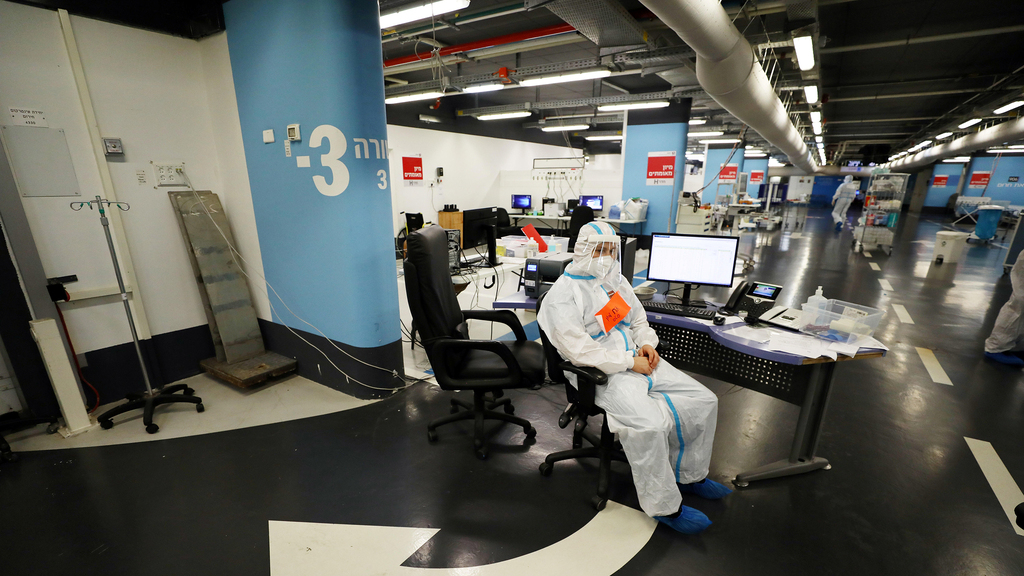 A member of the medical team has a momentary break at the coronavirus ward in the parking garage of the Rambam Healthcare Campus in Haifa (Photo: Reuters) מחלקת קורונה ברמב"ם חיפה
