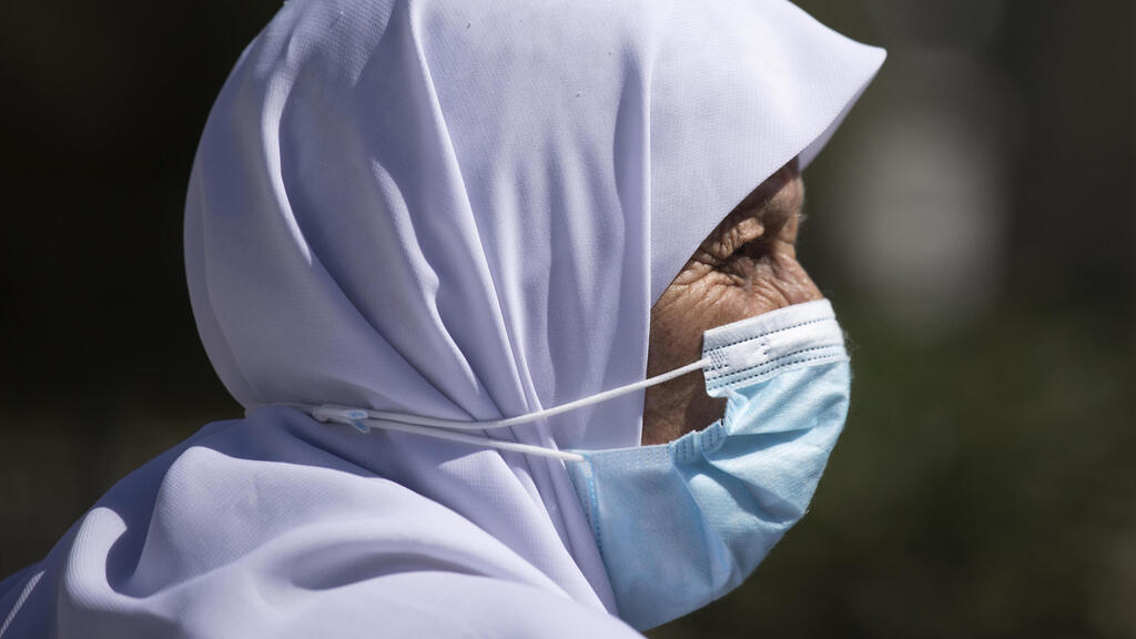 A Palestinian woman near the Damascus Gate in the Old City of Jerusalem last month (Photo: AP) פלסטינית פלסטינים עם מסכה ב שער שכם ב עיר העתיקה ב ירושלים ב -2 באוקטובר