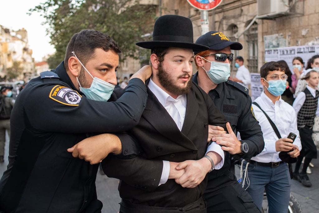 A Haredi man is arrested during protests in Jerusalem against the closure (Photo: Shalev Shalom) מחאות בירושלים