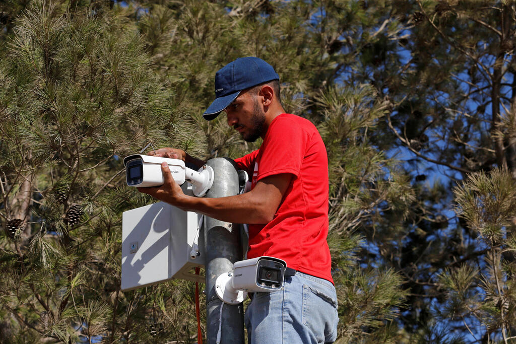 A worker installs a video surveillance system in the Palestinian village of Kisan (Photo: Reuters) A worker installs a video surveillance system to keep an eye on nearby Israeli settlers who Palestinians accuse of frequent attacks, in the village of Kisan in the Israeli-occupied West Bank