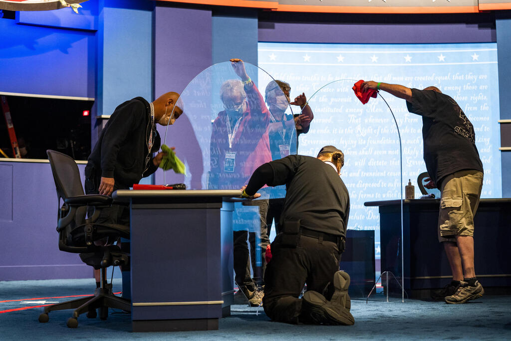  Workers install plexiglass panels between the candidates’ desks for the 2020 vice-presidential debate between US Vice President Mike Pence and Senator Kamala Harris 