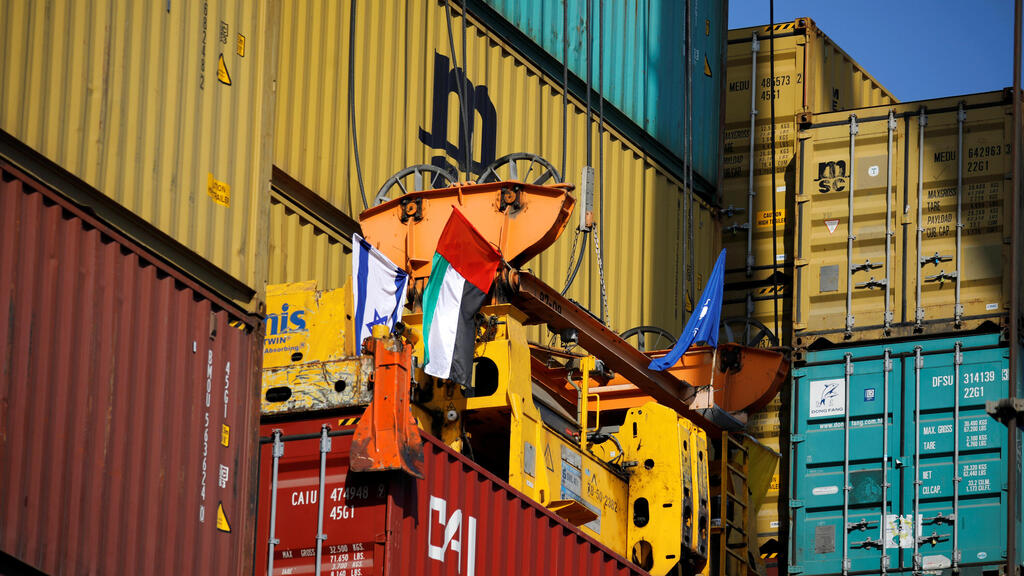 Containers carrying goods from the United Arab Emirates, which entered Israel on an MSC cargo ship, are unloaded with a cargo crane bearing Israeli and Emirati flags at Haifa's port