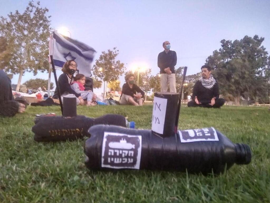 הפגנה ומייצג "צוללות" הקורא לוועדת חקירה במצפה רמון (צילום: הדגלים השחורים) הפגנת הדגלים השחורים במצפה רמון