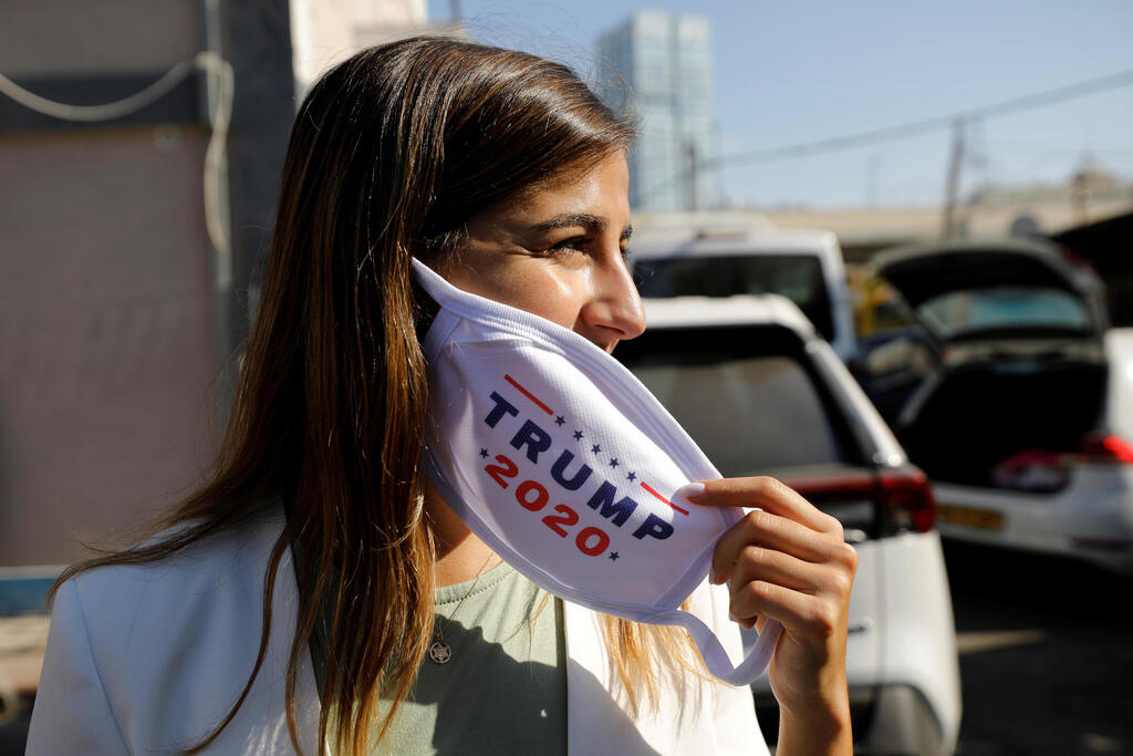 Activists from Republicans Overseas Israel, paste a pro-Trump election campaign ad on a minibus in Tel Aviv, Israel October 14, 2020 