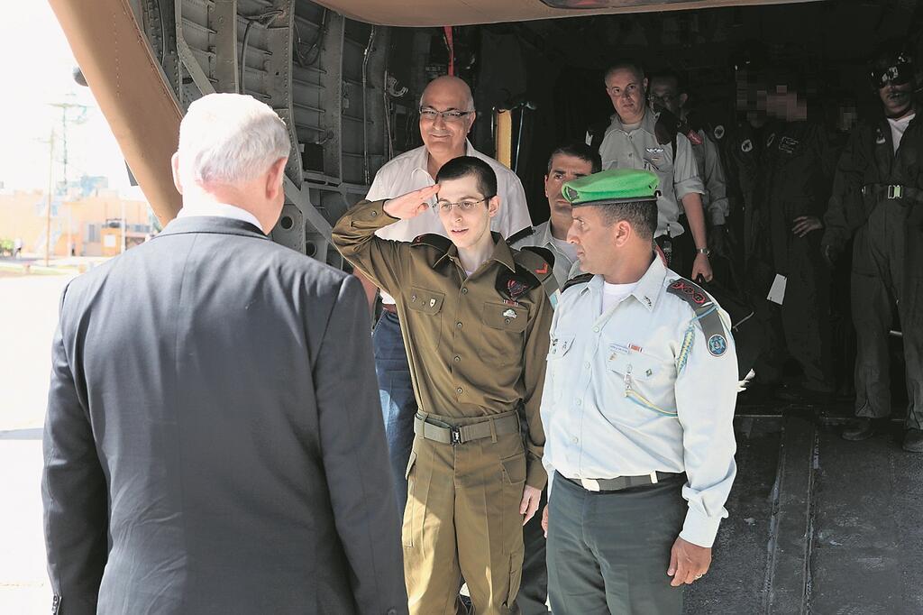 Gilad Shalit saluting Prime Minister Benjamin Netanyahu upon his release from 5 years of captivity (Photo: Avi Ohayun, Ltd) גלעד שליט מצדיע לבנימין נתניהו, דוד מידן מאחוריו