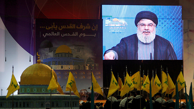 Hezbollah members watch as the terror group's leader Hassan Nasrallah delivers an address via video  