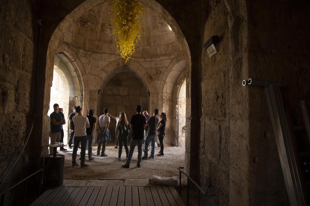 A group gathers under a work by American sculptor Dale Chihuly at the Tower of David Museum in the Old City of Jerusalem, Oct. 28, 2020 