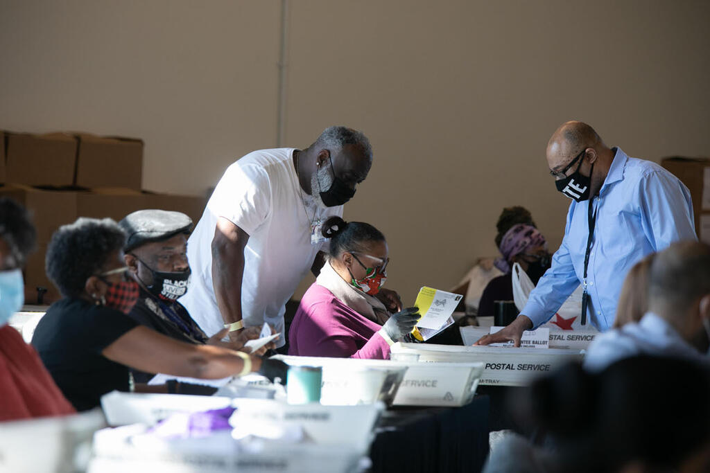 קלפי ארה"ב עובדי הבחירות סופרים את פתקי ההצבעה של מחוז פולטון בארנה של מדינת החווה באטלנטה ג'ורג'יה