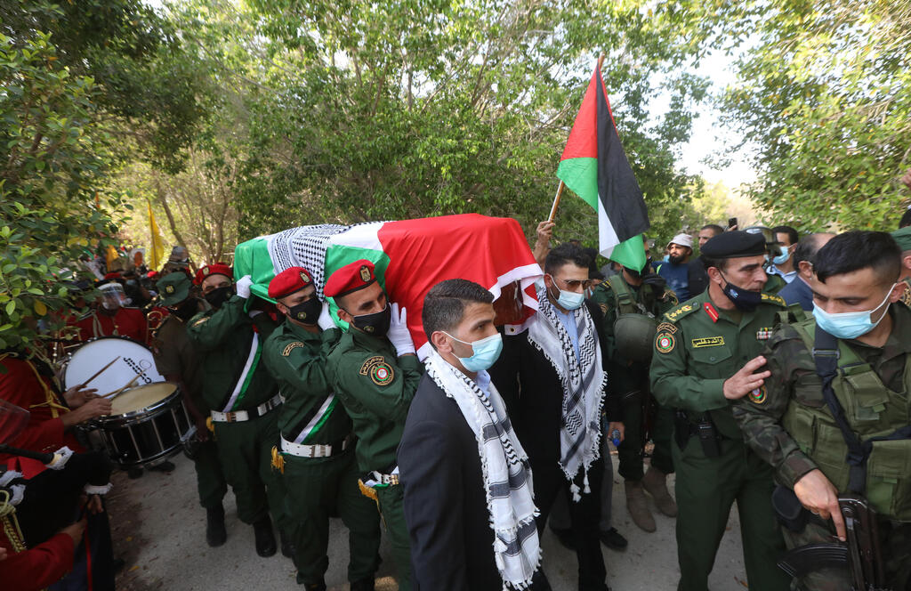 Palestinian honor guard and the two sons of late Palestinian politician and diplomat Saeb Erekat carry his coffin during funeral in the West Bank city of Jericho 