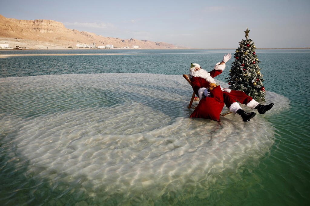 A man dressed as Santa Claus in the Dead Sea (Photo: Reuters) סנטה קלאוס עם עץ אשוח ב ים המלח
