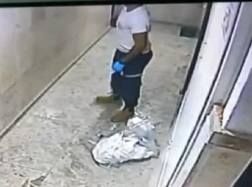 A Magen David Adom worker is caught on camera spitting on images of Jesus and Mary in a Jaffa apartment building (Photo: Screenshot) עובד מד"א יורק על תמונות של ישו ומריה
