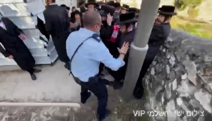 קצין משטרה בעט במפגינים חרדים במהלך הפגנה אשר מחו על הרחבה של מלון במקום של קברי יהודים