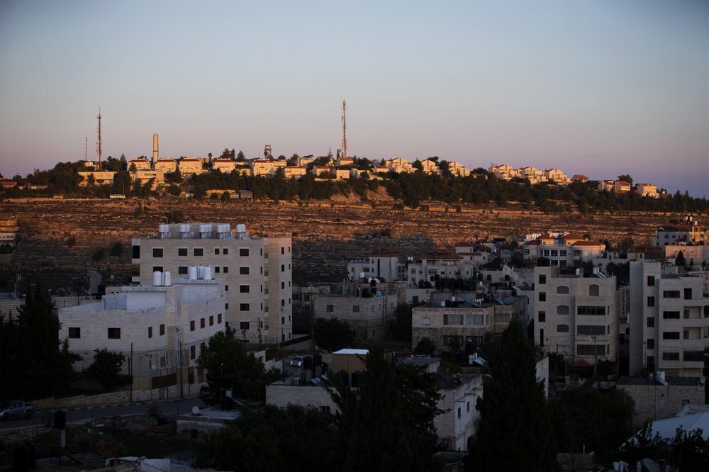 Part of the Israeli settlement of Psagot, top, overlooks Palestinian the West Bank city of Al-Bireh 