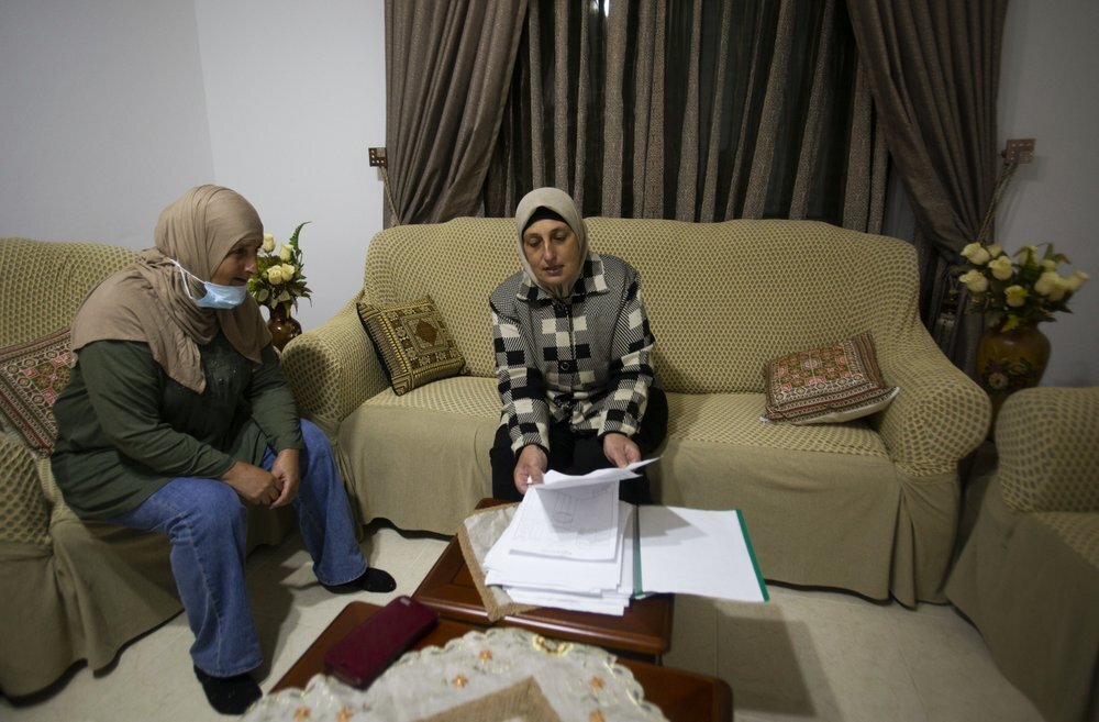 Palestinian sisters Kainat and Karema Quraan show documents of land ownership of land on which some of the Psagot vineyards and a winery building were established, at their home in the West Bank city of Al-Bireh 