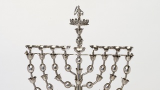 מנורת חנוכה בדגם מנורת המקדש ודמות יהודית בראשה