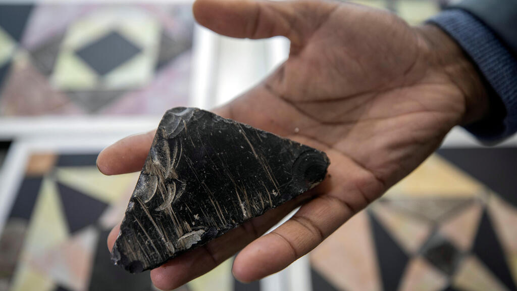 Israeli archaeologist Assaf Avraham displays a stone, that according to archaeologists, was used for flooring in Jerusalem's Roman-era Jewish temple,