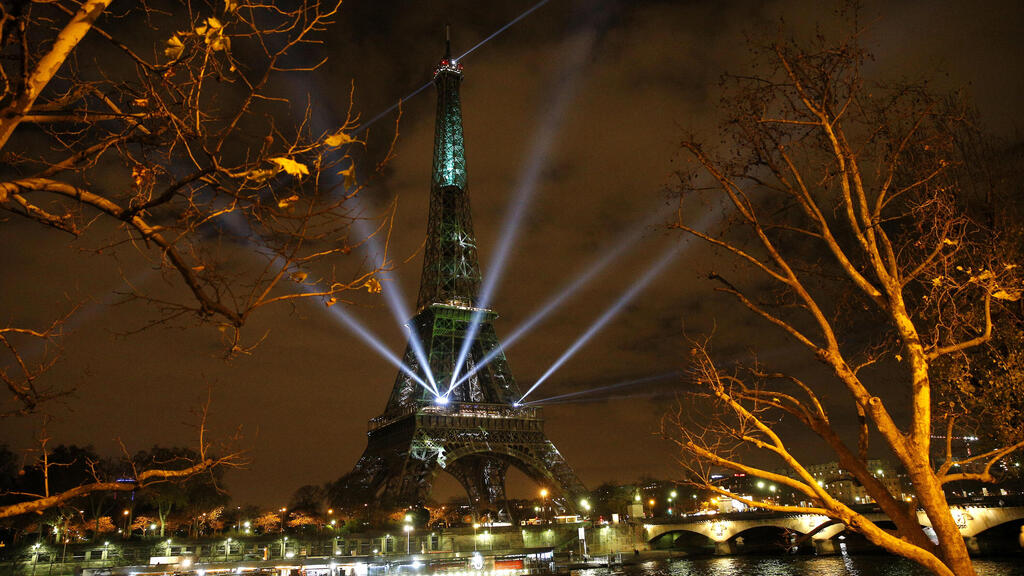 The Eiffel Tower lights up with colors and messages of hope on the eve of the COP21 climate conference in Paris