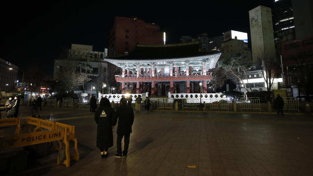 Visitors walk in front of the Bosingak pavilion where its annual New Year's Eve bell-ringing ceremony was canceled in Seoul, South Korea (Photo: AP) Visitors walk in front of the Bosingak pavilion where its annual New Year's Eve bell-ringing ceremony was cancelled in Seoul, South Korea