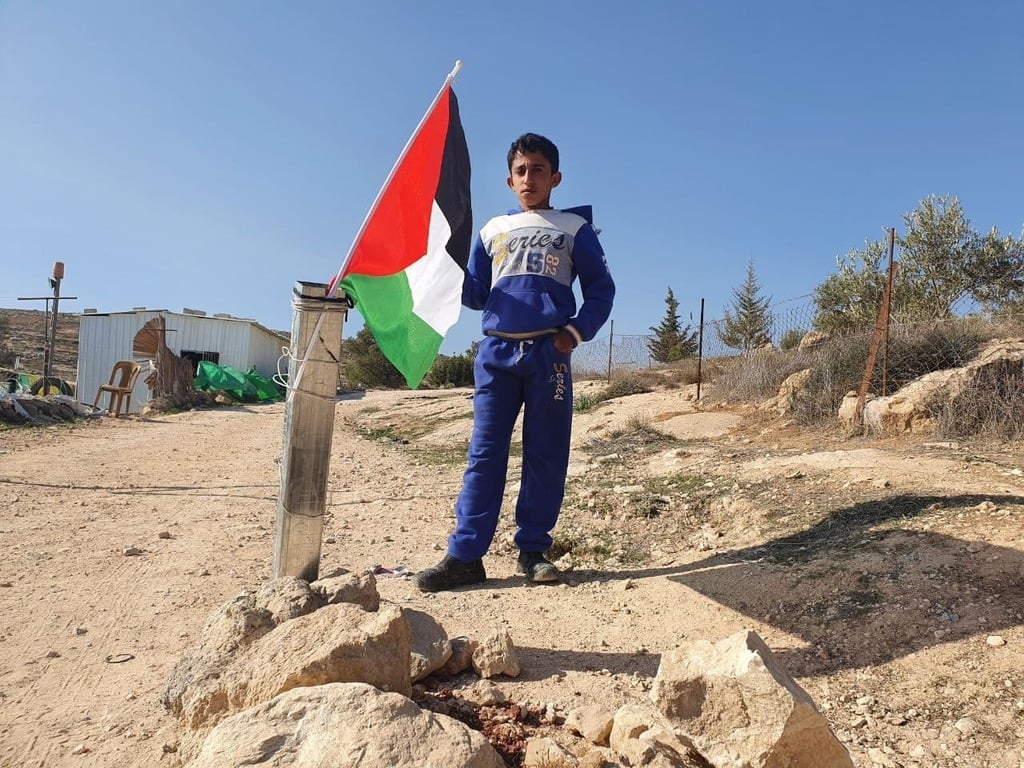 A local Palestinian boy stands by the monument to the incident (Photo: Elio Levy) האנדרטה שהוקמה במקום התקרית, הרחוב ייקרא על שמו של אבו עראם