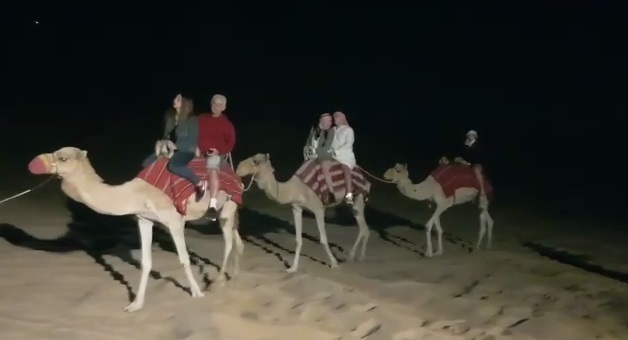מספר זוגות ישראלים רוכבים על גמלים במדבריות דובאיים
