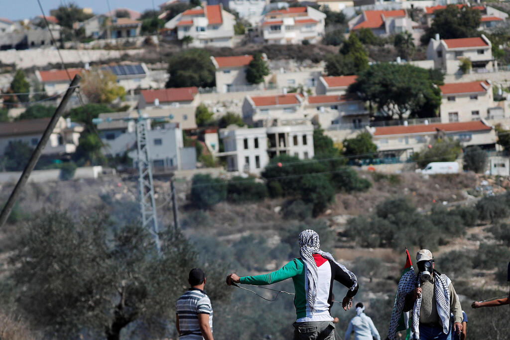 Palestinian demonstrators stand in front of a Jewish settlement during a protest, in Kafr Qaddum in the West Bank 