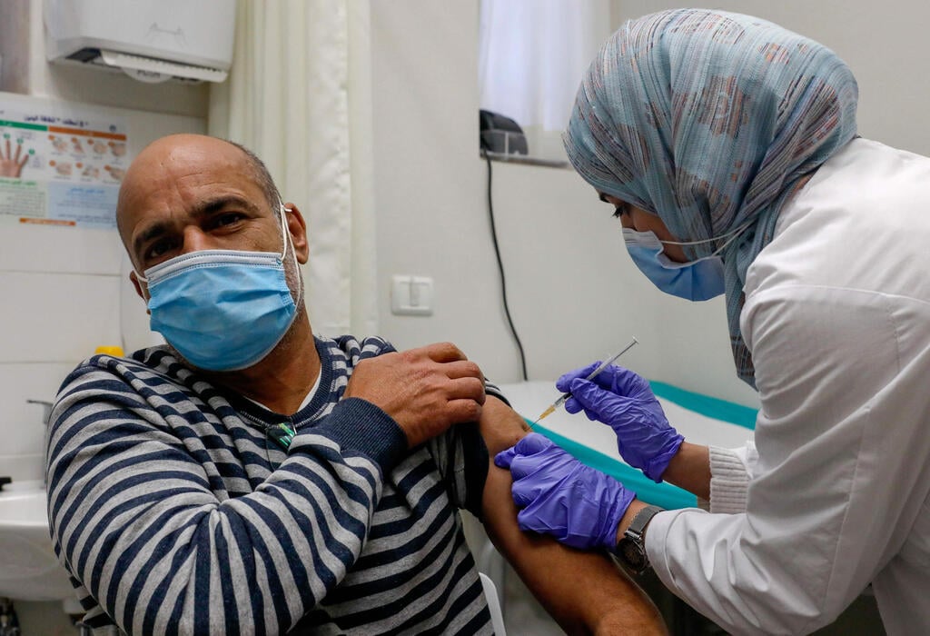 A Palestinian resident of East Jerusalem being inoculated for coronavirus (Photo: AFP) חיסונים בירושלים